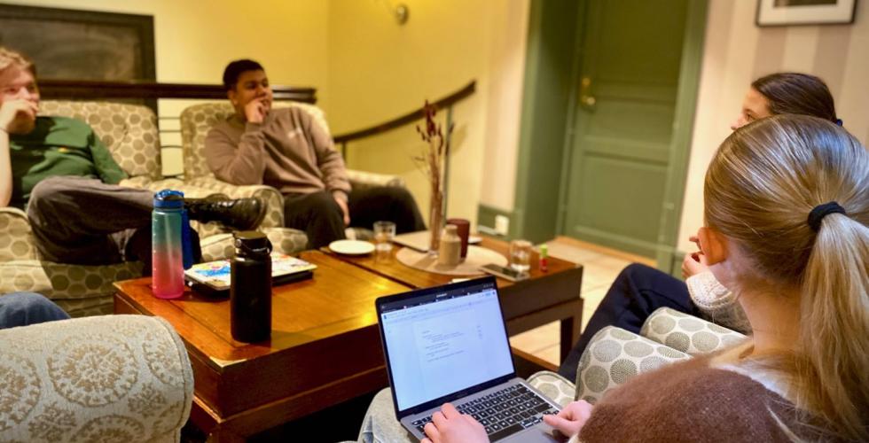 URO-ambassad&oslash;rer sitter i en sofagruppe og skriver p&aring; en pc. 