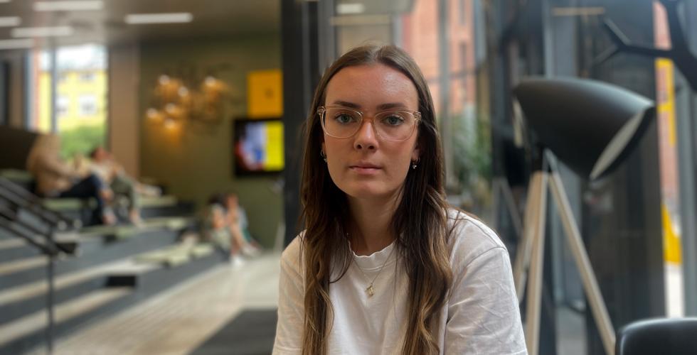 Janne sitter p&aring; studentkafeen med et seri&oslash;st uttrykk