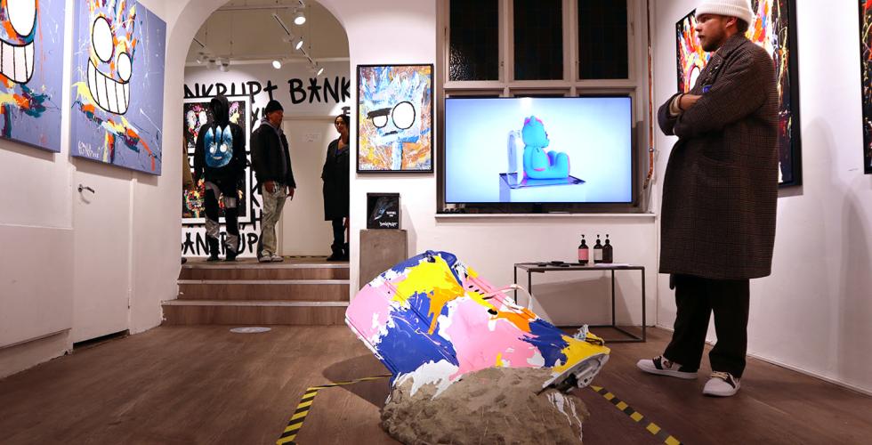 En fyr st&aring;r og beundrer maleriene til King Bankrupt 