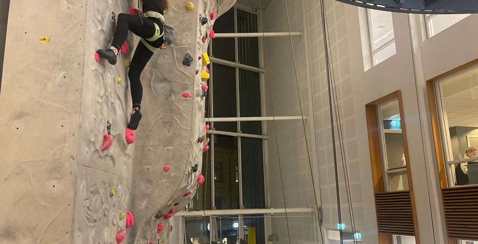 Jente p&aring; vei opp klatreveggen. 