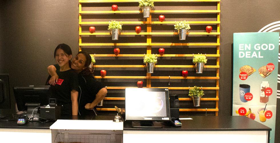 To damer som jobber i en kafe p&aring; skolen gir hverandre en klem