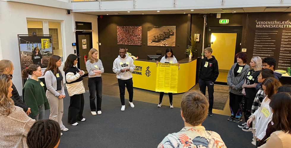 Kurslederne viser frem plakat av menneskerettighetene til deltakerne p&aring; kurset