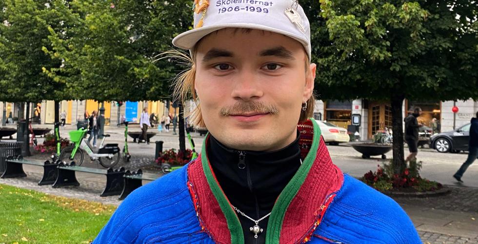 Bilde av Mihkkal H&aelig;tta, en mann i samekofte utenfor Stortinget i Oslo. 