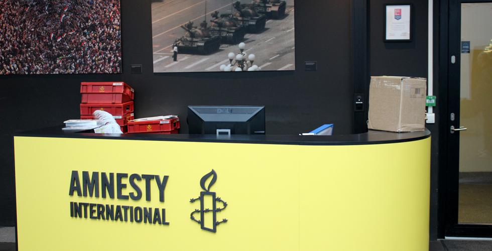 Resepsjonen i Amnesty st&aring;r tom. Deres gule logo er fremtredende i bildet