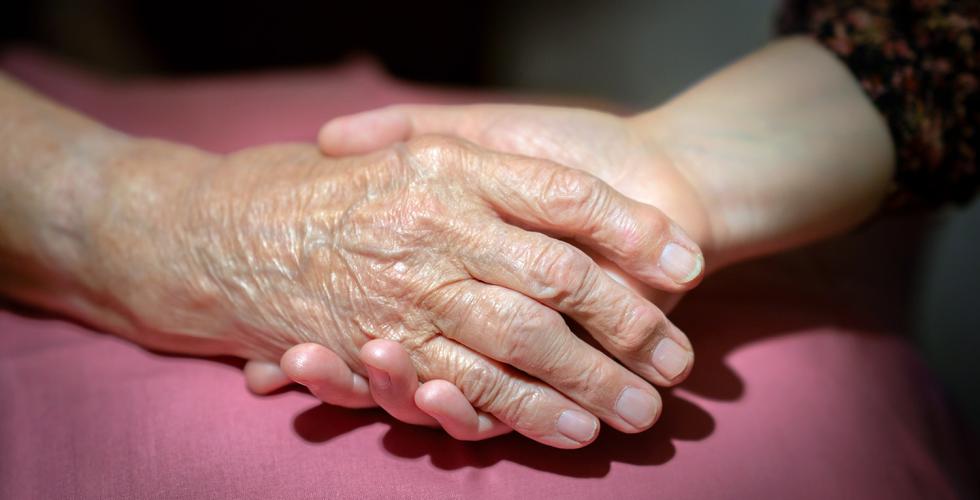 N&aelig;rbilde av datter og pappa som sitter og holder hender