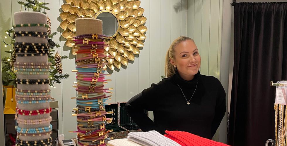 Butikkmedarbeider som st&aring;r bak disken