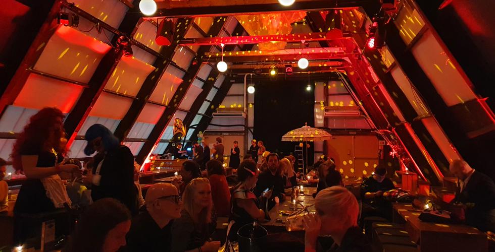 Det er klart for filmvisning av. The Rocky Horror Picture Show, p&aring; Salt i Oslo. Lokalet er preget av en dempet r&oslash;d belysning, og foran den store filmskjermen ser man kostymekledde mennesker, sitte rundt bordene - klare for &aring; se film. 