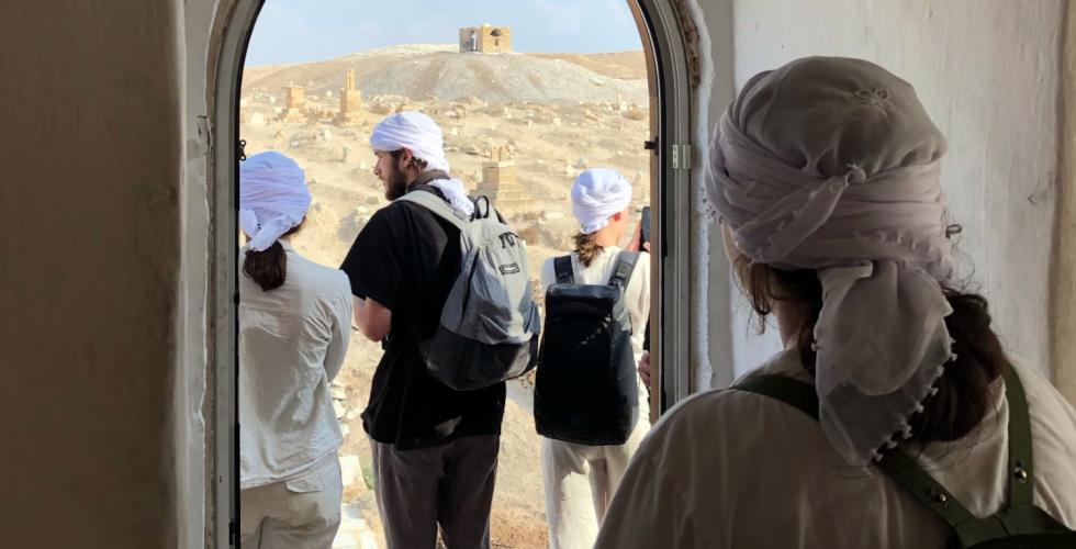 Fire folkeh&oslash;gskole-elever st&aring;r med ryggen vendt mot kamera, og kikker p&aring; &oslash;rkenen.