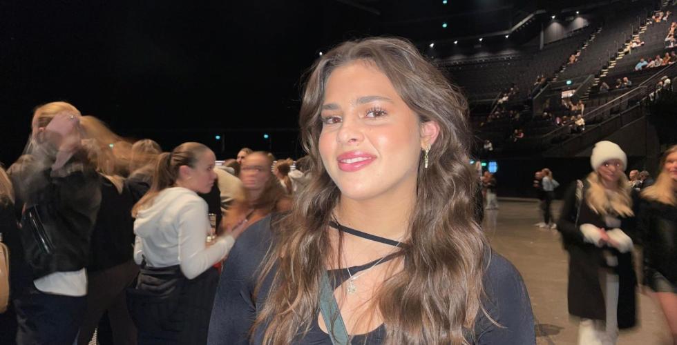 Jente m&oslash;rkt h&aring;r, svart genser, st&aring;plass p&aring; konsert