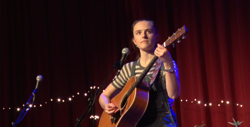 Kvinne som spiller gitar p&aring; scenen