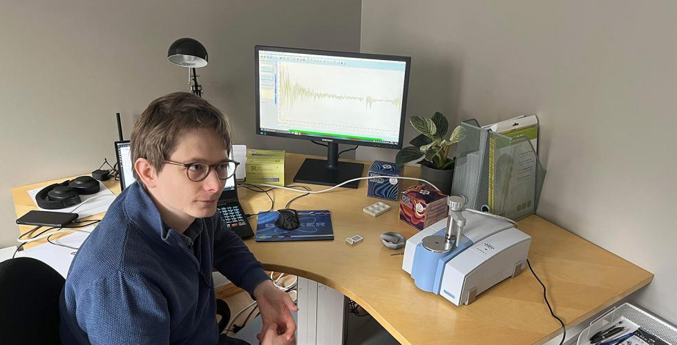 J&oslash;rn Kl&oslash;vfjell Mjelva sitter ved pulten sin, der han analyserer rusmidler med en test-maskin, og to pc-skjermer. 