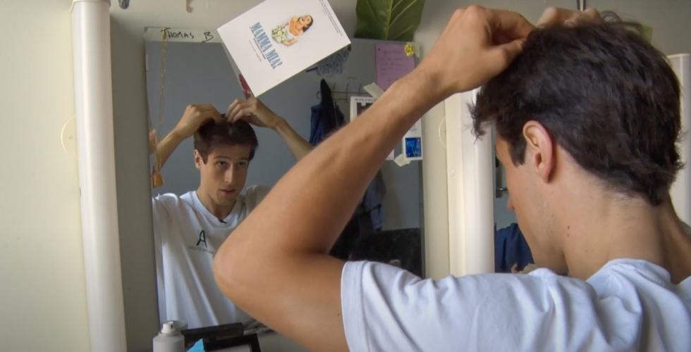 Thomas Brasel. En ung mann som ser seg i speilet, mens han ordner h&aring;ret. 