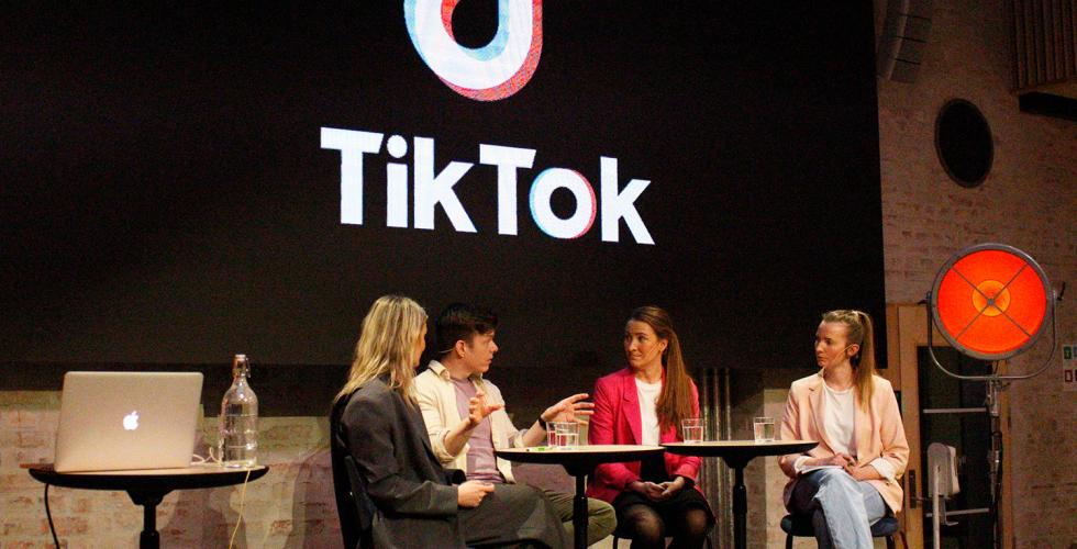 Debatt p&aring; pressens hus med 4 mennesker p&aring; en scene. Skjerm med stor tiltok-logo bak.